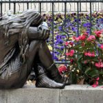 A NEM OKÉ kampány magányosan szomorkodó kislányt ábrázoló vándorszobra egy iskola kertjében