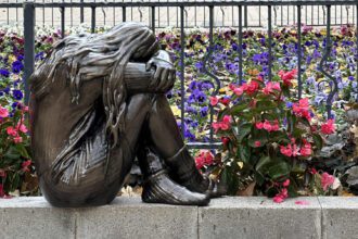 A NEM OKÉ kampány magányosan szomorkodó kislányt ábrázoló vándorszobra egy iskola kertjében